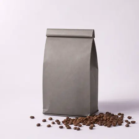 Campaign creative: a matte kraft-grey specialty coffee bag beside whole beans.