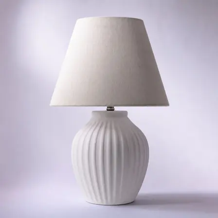Campaign creative: a ribbed ceramic table lamp with a warm linen shade.